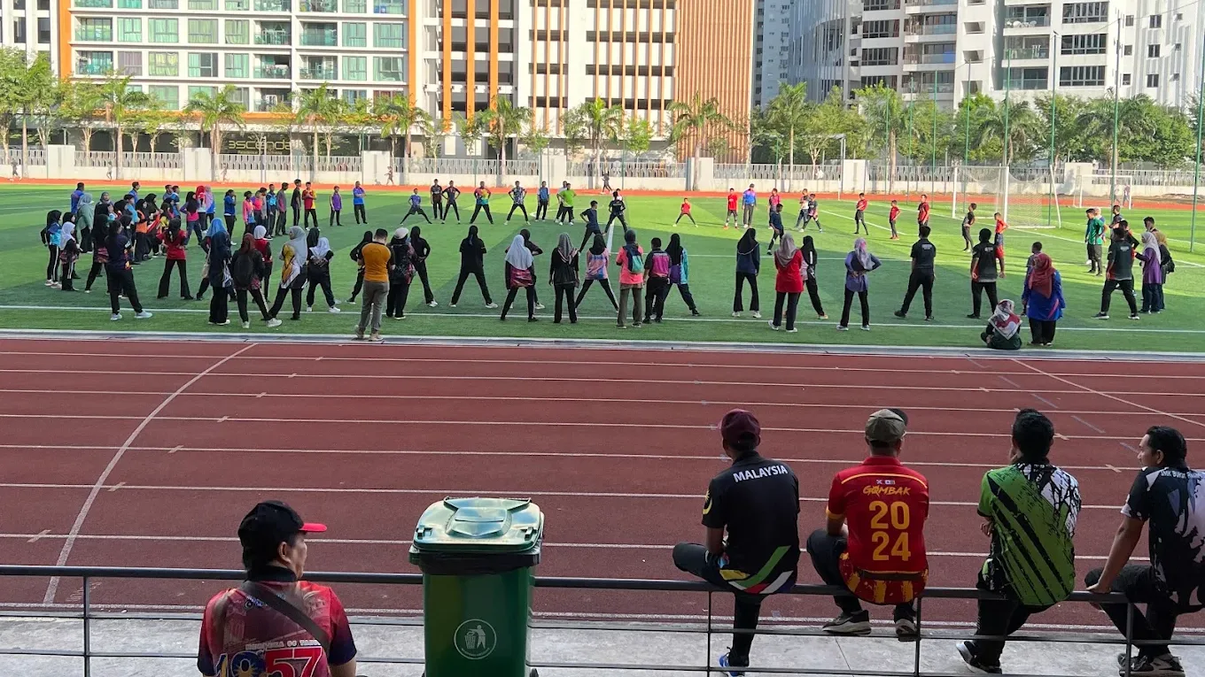 The squad spread across the field in a warm-up formation, seen from the stand